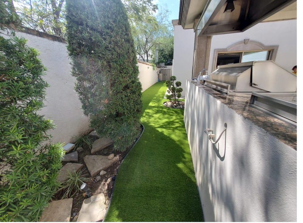 Corredor residencial con pasto sintético EasyGarden instalado — jardín lateral impecable