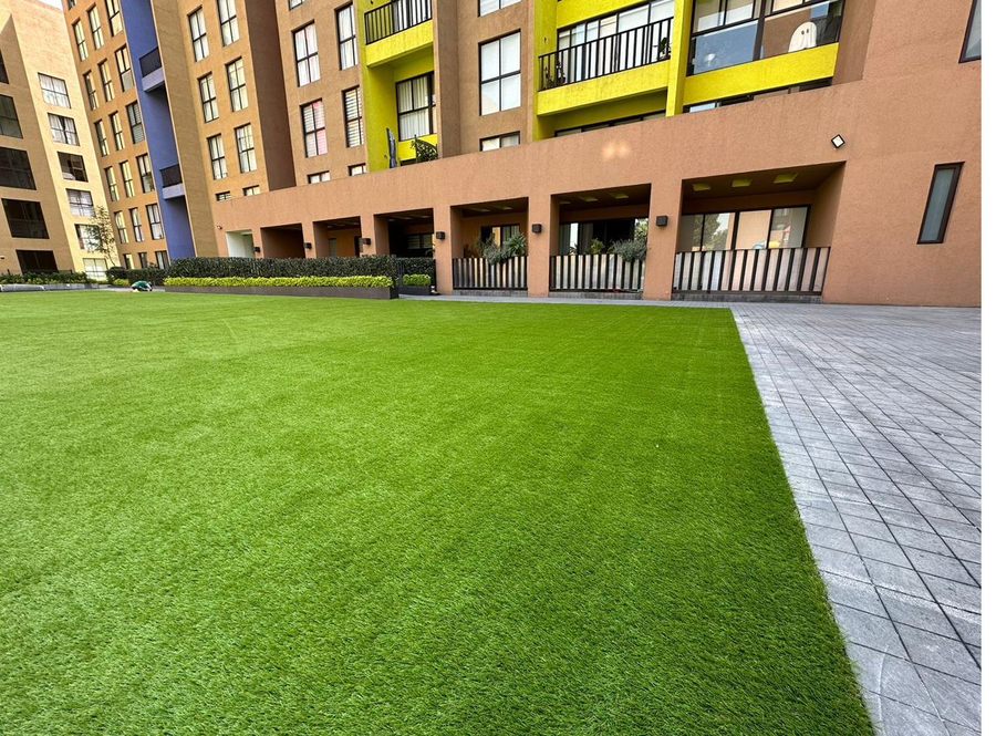 Proceso de instalación de pasto sintético EasyGarden en área verde de condominio residencial — resultado final impecable